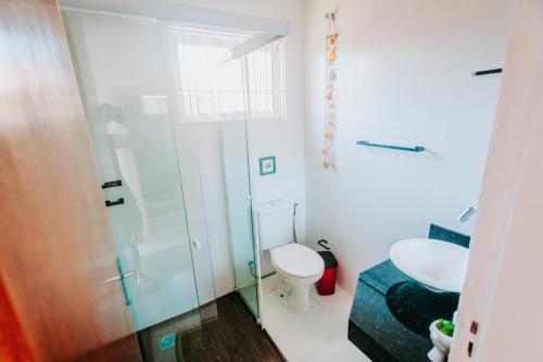 a bathroom with a toilet and a glass shower at Casa c/ Piscina e Área Gourmet Perto da Praia in São Sebastião