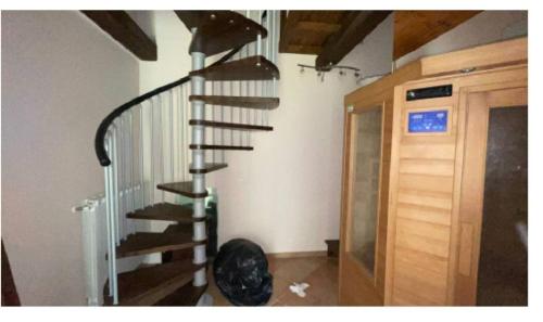 uma escada em espiral preta num quarto com uma porta em Luxury suite la Grotta del Vento em Gallicano