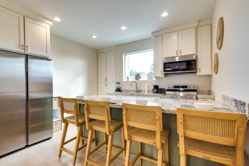 a kitchen with a counter with chairs and a refrigerator at WFH-Friendly Brownsville Home with Private Patio in Brownsville