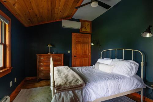 1 dormitorio con cama y pared verde en Stella Firma en Bloomville