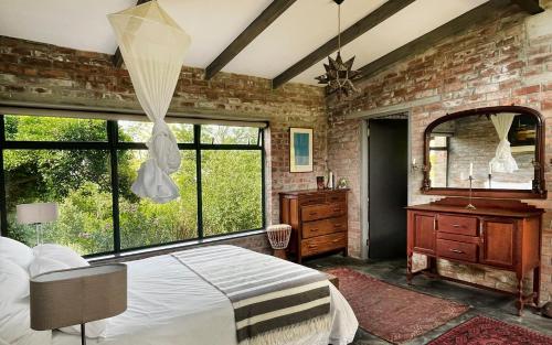 a bedroom with a bed and a brick wall at Brickhouse in Monteray