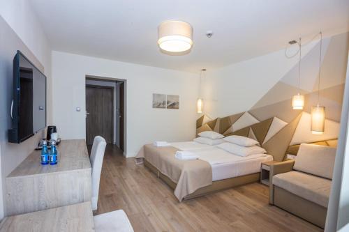 a bedroom with a bed and a table and a couch at Skałka Zieleniec in Duszniki Zdrój