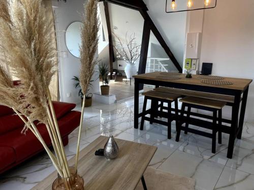 ein Wohnzimmer mit einem roten Sofa und einem Tisch in der Unterkunft Magnifique appartement de charme in Besançon