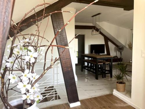 una sala de estar con una mesa y un jarrón de flores en Magnifique appartement de charme en Besançon