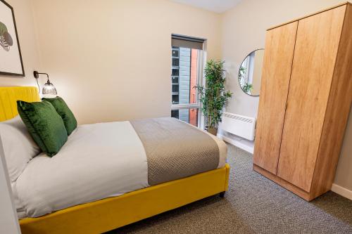 a bedroom with a bed and a wooden cabinet at Host & Stay - Ropewalks Quarters in Liverpool