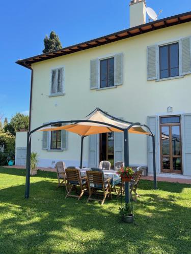 a table and chairs under an umbrella in front of a house at Casa le Rondini Toscana in Bucine