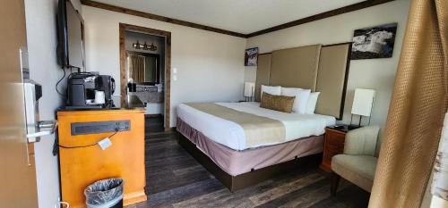 Habitación de hotel con cama y TV en The Dalles Inn en The Dalles