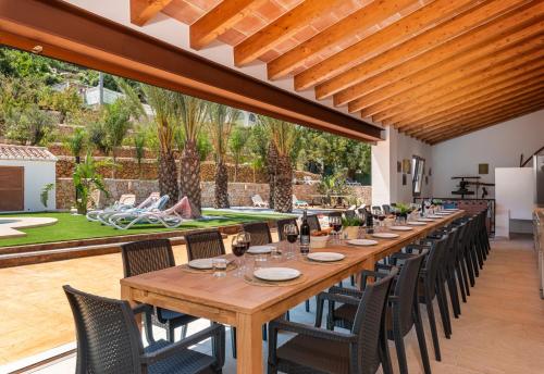 a long wooden table and chairs in a patio at Villa Joan - PlusHolidays in Calpe