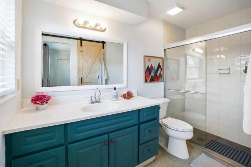 ein Badezimmer mit einem Waschbecken, einem WC und einem Spiegel in der Unterkunft Boho Villa 10 mins from Siesta in Sarasota