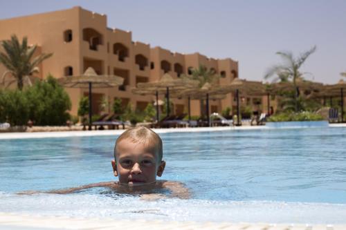 a young boy in a swimming pool at a resort at Blend Elphistone Resort Marsa Alam in Abu Dabab