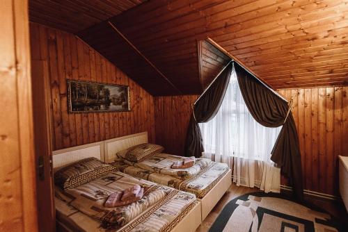 2 camas individuales en una habitación con ventana en Highland en Yablunytsya