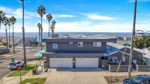 a blue house with a garage and palm trees at Tower 9 #1 in Oceanside