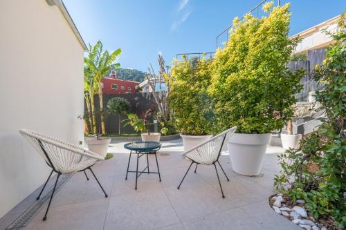 a patio with chairs and a table and plants at Deluxe VILLA GRAZIELLA 200 M FROM THE BEACH in Èze