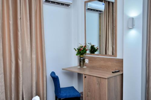 a bathroom with a mirror and a blue chair at Hôtel Joya Paradise & SPA Djerba in Djerba