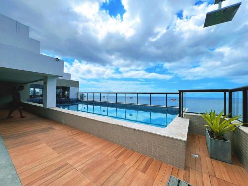 a balcony with a swimming pool on top of a building at Barra Premium residencial in Salvador