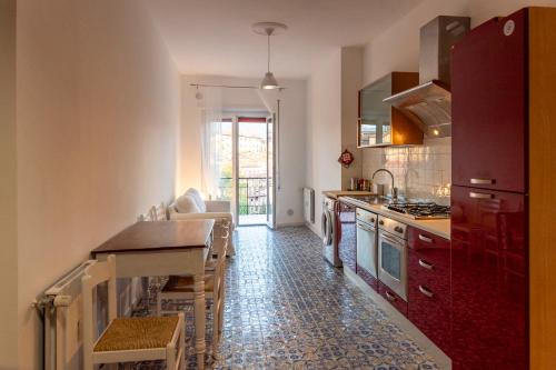 cocina con armarios rojos y encimera en Orchidee apartment, en Rieti