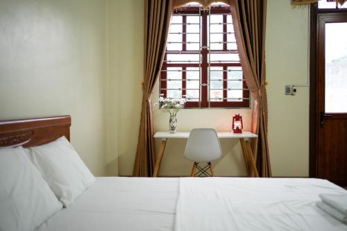 - une chambre avec un lit, une table et une fenêtre dans l'établissement Tom's House Motel & Motorbikes, à Làng Me