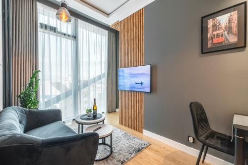 a living room with a couch and a tv on a wall at Q18 ApartHotel in Bydgoszcz