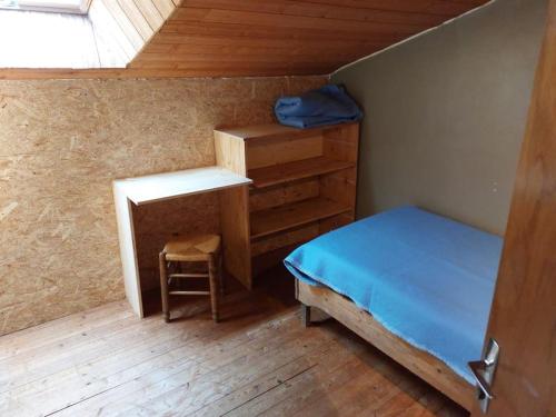 Habitación pequeña con cama y escritorio. en maison de caractère en Saint-Georges-de-Pointindoux