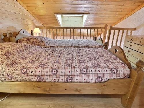 - une chambre avec un lit en bois dans une cabine dans l'établissement Duplex Chaleureux, Skis aux Pieds - Proche Commerces, 6 Pers., Balcon Sud - FR-1-182-231, à Les Allues
