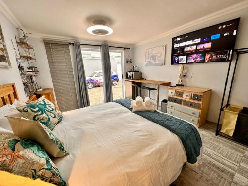 Un dormitorio con una cama grande con un televisor en la pared. en 4 on Meerenbosch, en Knysna