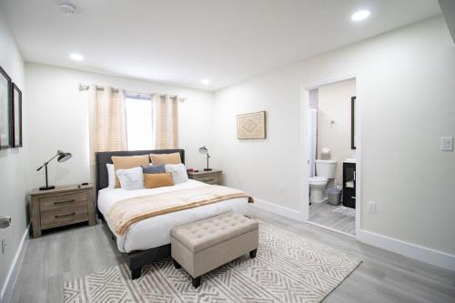 a white bedroom with a large bed and a bathroom at Good Vibes Oasis - Cozy townhome with parking in Cutler Bay