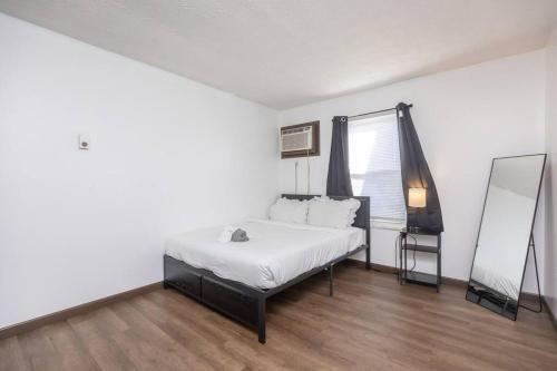 Habitación blanca con cama y espejo en Quiet 2-Bedroom Apartment, en Dayton