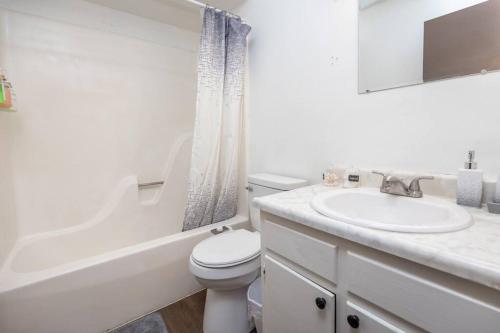 Baño blanco con aseo y lavamanos en Quiet 2-Bedroom Apartment, en Dayton