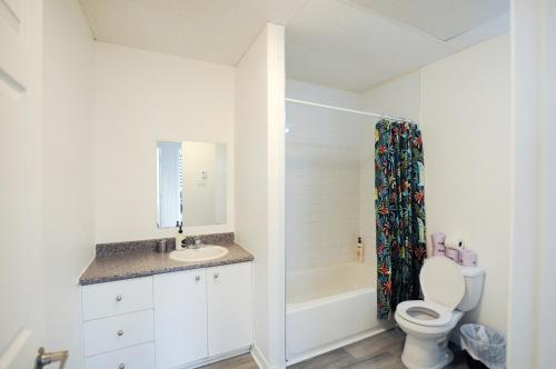 a white bathroom with a toilet and a sink at Le 1066 - Logement spacieux à Limoilou in Quebec City
