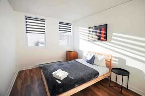 1 dormitorio con 1 cama y 2 ventanas en Le 1066 - Logement spacieux à Limoilou, en Quebec