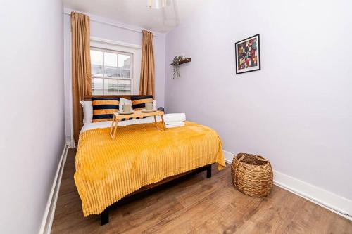 a bedroom with a bed with a yellow blanket at [Covent Garden-Oxford Street] Central London Apartment in London