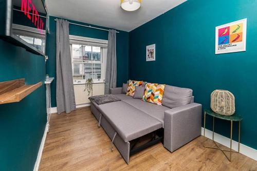 sala de estar con sofá y pared azul en [Covent Garden-Oxford Street] Central London Apartment, en Londres