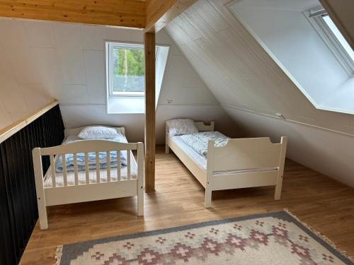 a attic room with two beds and a rug at Moderne Wohnung :: traumhafte Natur in Moholm