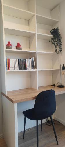 een bureau met een zwarte stoel en boekenplanken bij Grand studio proche de Paris in Saint-Maur-des-Fossés
