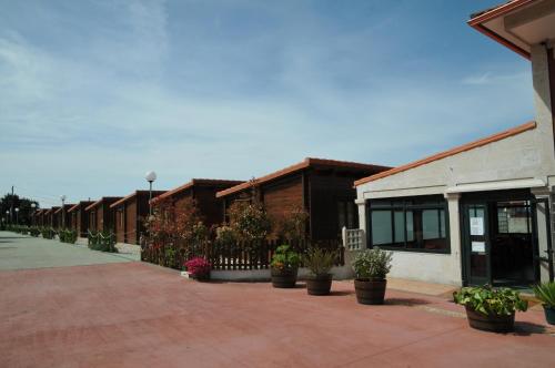 a row of buildings with potted plants on a sidewalk at Bungalows Sol e Mar in Hio