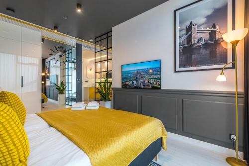 a bedroom with a bed and a tv on the wall at Q18 ApartHotel in Bydgoszcz