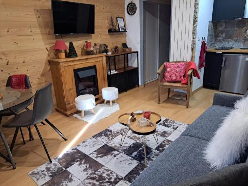 sala de estar con sofá y chimenea en STUDIO 2 ALPES STYLE CHALET au PIED DE TELESIEGE DU DIABLE en Les Deux Alpes