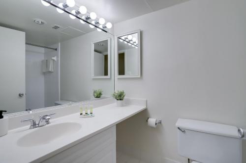 a white bathroom with a sink and a mirror at Enjoy your stay at this condo in Crystal City in Arlington