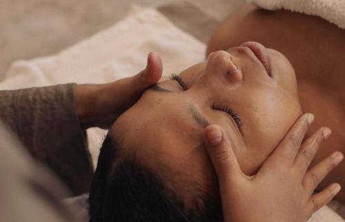 a woman laying on a bed with her eyes closed at Palais Nazha Fes - Luxury Lodging in Fès