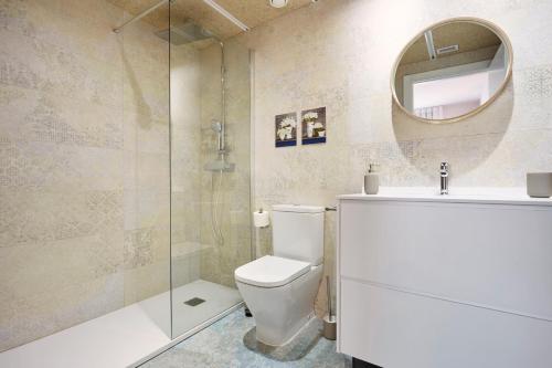 uma casa de banho com um WC, um lavatório e um espelho. em Urban Sabadell Apartamentos em Sabadell
