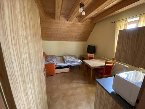 Una habitación con una cama y una mesa en una habitación en Apartmány F - chata SVOBODĚNKA, en Dolní Moravice
