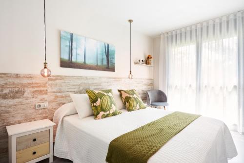 1 dormitorio con 1 cama con manta verde y blanca en Urban Sabadell Apartamentos, en Sabadell