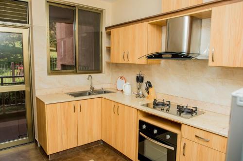 a kitchen with wooden cabinets and a sink at Rohi Apartments in Kigali