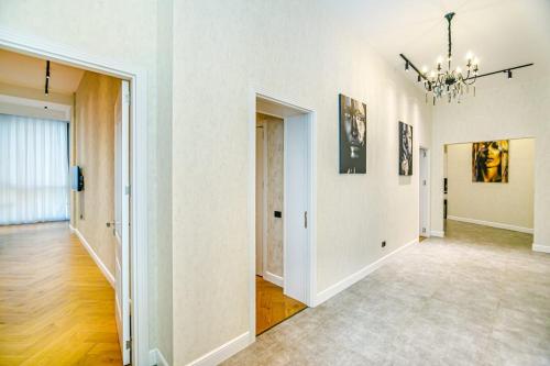 a large room with white walls and a chandelier at Two-Bedroom Apartment City Center in Baku