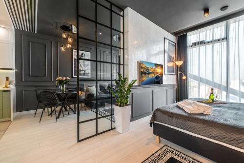 a bedroom with a bed and a dining room at Q18 ApartHotel in Bydgoszcz