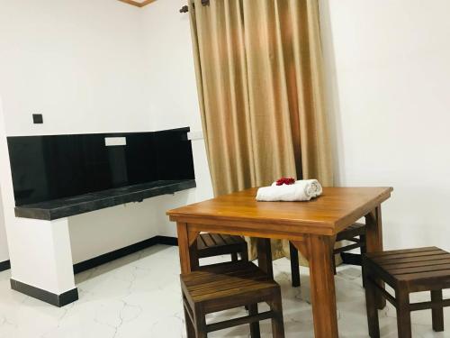 a dining room with a table and a flat screen tv at Samaro Resort in Matara
