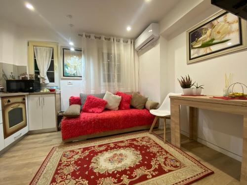 ein Wohnzimmer mit einer roten Couch in der Küche in der Unterkunft Central Welcoming Apartment in Tirana in Tirana
