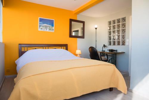 Dormitorio amarillo con cama y escritorio en 3C’s Athens South @Delta: SNFCC / Faliro Seaview Penthouse en Athens