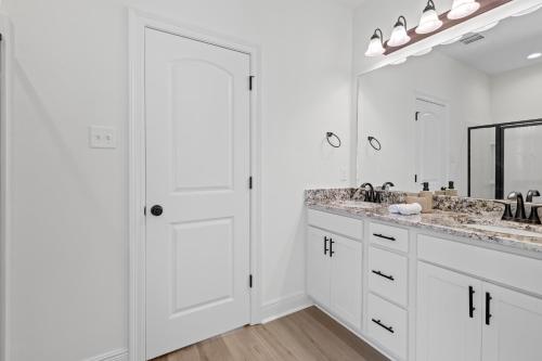 a white bathroom with two sinks and a large mirror at Cajun Palace Iowa, LA in Iowa