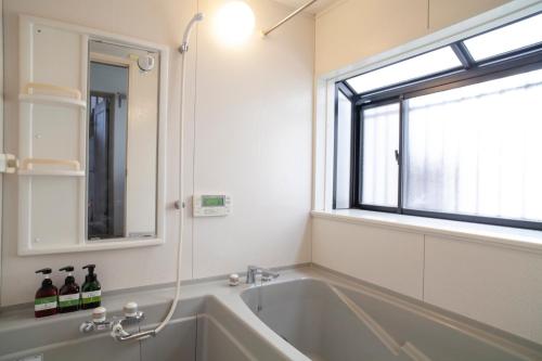 a bath tub in a bathroom with a window at Cachtte Nagisa - Vacation STAY 95387v in Zushi